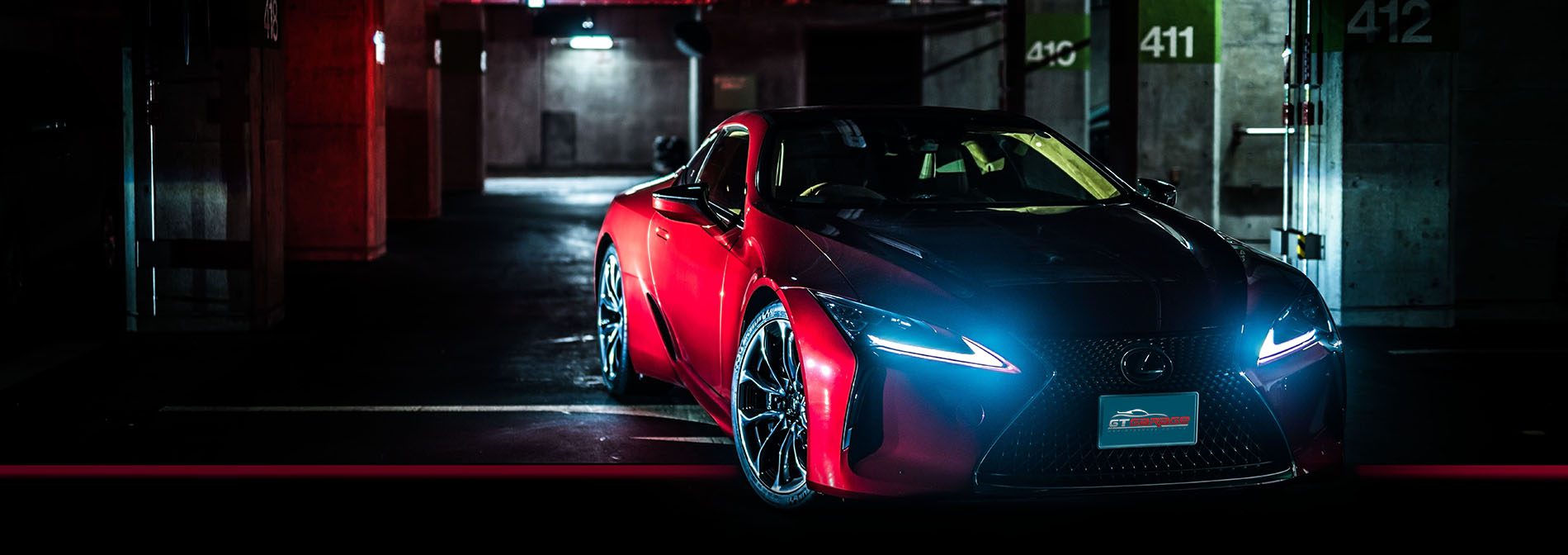 Red sports car parked in a dark garage