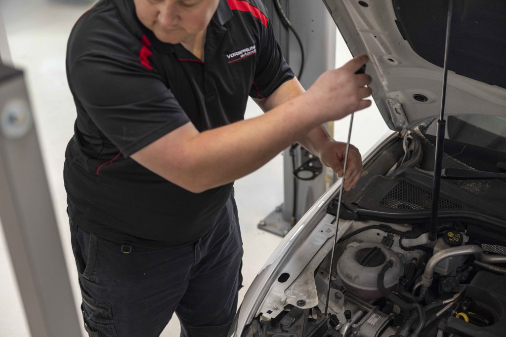 Vorsprung Automobil technician working in a European car engine bay