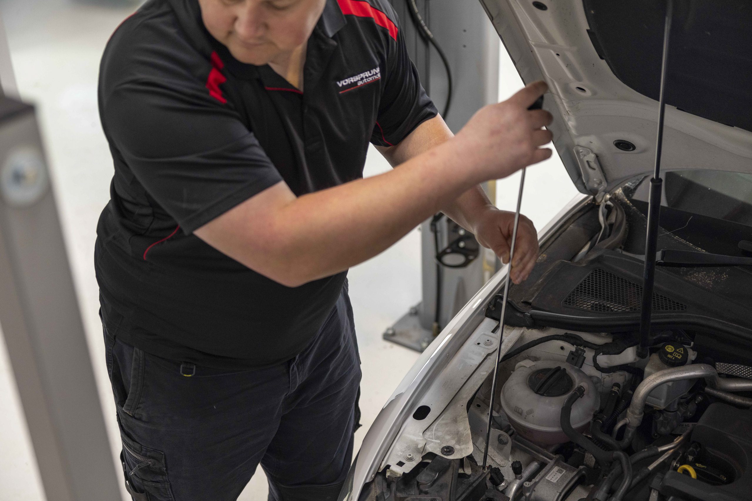 Vorsprung Automobil technician working in a European car engine bay