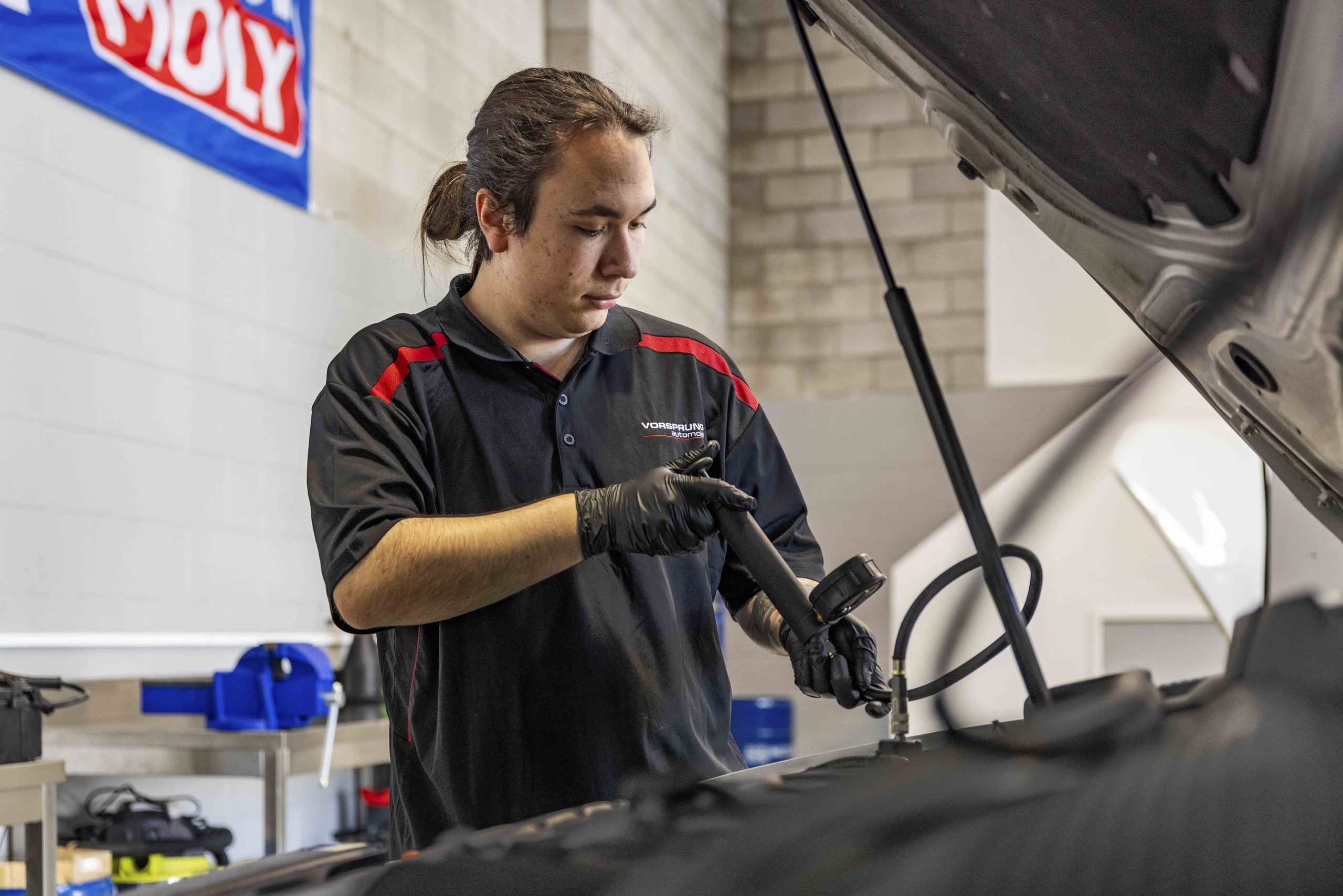 Technician servicing a European car engine at Vorsprung Automobil