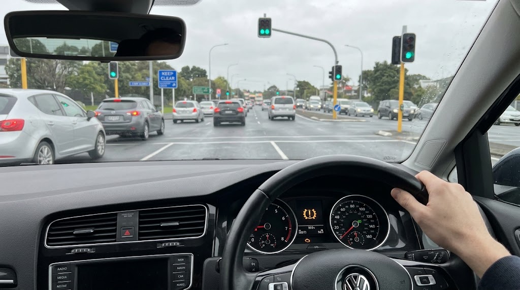 Car dashboard displaying an illuminated yellow warning light while stopped in city traffic, a common sign of a DSG gearbox issue
